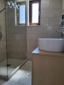 a bathroom with a sink and a glass shower at Villa Ypsi in Dhrámia