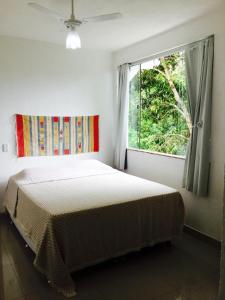una camera da letto con un letto e una finestra di Villa Vanuza a Santa Cruz Cabrália