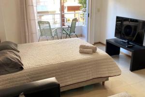 1 dormitorio con 1 cama grande y TV en Adorable Ambiente en Buenos Aires