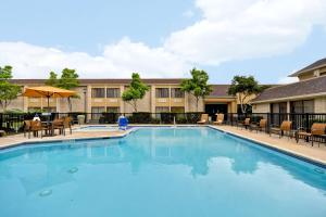 a swimming pool at a hotel with tables and chairs at Courtyard Houston I-10 West/Energy Corridor in Houston