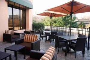 a patio with tables and chairs and an umbrella at Courtyard Shelton in Shelton