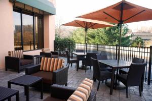 un patio con mesas, sillas y una sombrilla en Courtyard Shelton, en Shelton