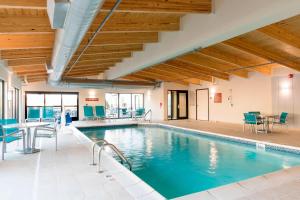 una piscina con sillas azules y una mesa en TownePlace Suites by Marriott Ontario-Mansfield, en Mansfield