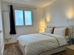 1 dormitorio con 1 cama blanca grande y ventana en Roosevelt Cosy 2BR Easy Access to Paris Free parking en Saint-Germain-en-Laye