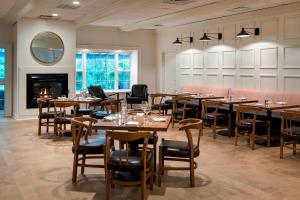 um restaurante com mesas e cadeiras e uma lareira em Delta Hotels by Marriott Basking Ridge em Basking Ridge