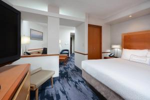 a hotel room with a bed and a flat screen tv at Fairfield by Marriott Inn & Suites Charlottesville North in Charlottesville +24 photos