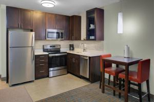 a kitchen with a stainless steel refrigerator and a table at Residence Inn by Marriott Dallas Allen/Fairview in Fairview