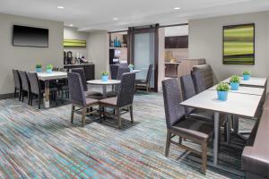 uma sala de jantar com mesas e cadeiras e uma televisão em Residence Inn by Marriott Dallas Allen/Fairview em Fairview