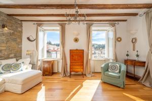 a bedroom with a bed and a chair and windows at Apartment Buena Vista Piran in Piran