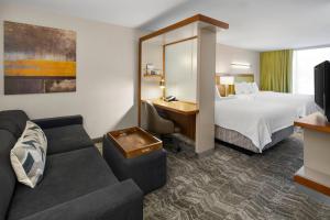 une chambre d'hôtel avec un lit et un canapé dans l'établissement SpringHill Suites by Marriott Flagstaff, à Flagstaff