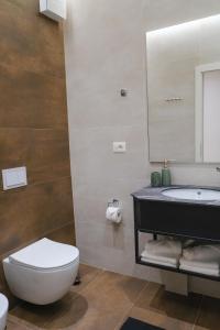 uma casa de banho com um lavatório, um WC e um espelho. em Lindi's Apartment 4 7 em Tirana