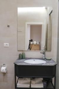 uma casa de banho com um lavatório e um espelho em Lindi's Apartment 4 7 em Tirana
