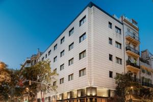 a white building on the corner of a street at AC Hotel Irla by Marriott in Barcelona