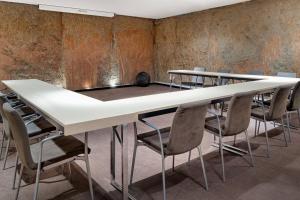 uma sala de conferências com mesas e cadeiras brancas em AC Hotel Irla by Marriott em Barcelona