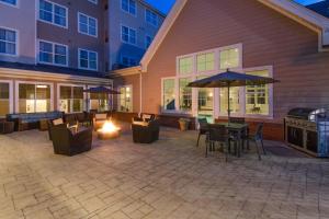 a patio with tables and chairs and an umbrella at Residence Inn by Marriott Fredericksburg in Fredericksburg