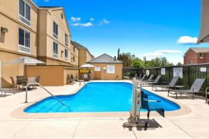 a swimming pool at a apartment complex with tables and chairs at Fairfield Inn by Marriott Evansville East in Evansville