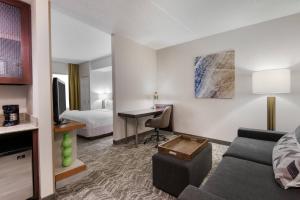 Habitación de hotel con sofá, cama y escritorio. en SpringHill Suites by Marriott Cleveland Solon en Solon