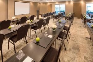 una sala de conferencias con mesas y sillas y una pantalla de proyección en AC Hotel Chicago Downtown en Chicago