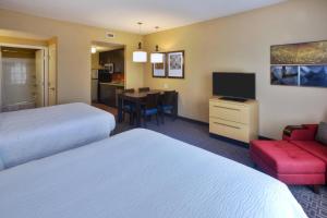 a hotel room with two beds and a dining room at TownePlace Suites by Marriott Franklin Cool Springs in Franklin