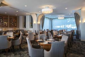 - un restaurant avec des tables et des chaises dans une salle dans l'établissement Renaissance Chicago O'Hare Suites Hotel, à Rosemont