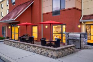 eine Terrasse mit Tischen, Stühlen und Sonnenschirmen in der Unterkunft TownePlace Suites by Marriott York in York