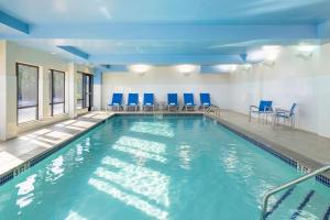 una piscina con sillas azules en un edificio en TownePlace Suites by Marriott York, en York