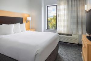 a hotel room with a large bed and a window at TownePlace Suites by Marriott York in York