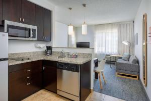 a kitchen with a counter top and a living room at TownePlace Suites by Marriott York in York