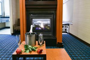 a fireplace in a room with a table with roses at Fairfield Inn Hartford Airport in Windsor Locks