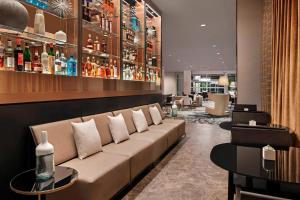 a lobby with a couch and a bar at AC Hotel by Marriott Gainesville Downtown in Gainesville