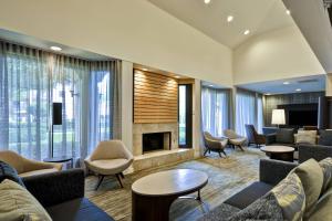 a lobby with couches and chairs and a fireplace at Courtyard Dallas Medical Market Center in Dallas