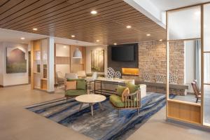 a lobby with chairs and a table and a tv at Fairfield Inn & Suites by Marriott Fresno North/Shaw Avenue in Fresno