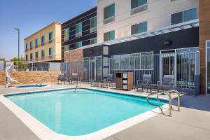 basen z krzesłami i budynek w obiekcie Fairfield Inn & Suites by Marriott Fresno North/Shaw Avenue w mieście Fresno