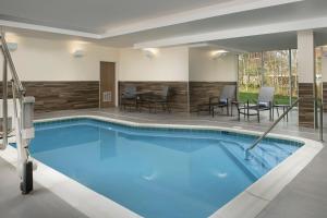 a pool in a hotel with chairs and a table at Fairfield by Marriott Inn & Suites Aberdeen in Aberdeen