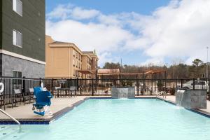 einen Pool in einem Hotel mit einem blauen Stuhl in der Unterkunft Residence Inn by Marriott Jackson Airport, Pearl in Pearl