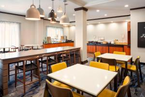 a restaurant with tables and chairs and a counter at Fairfield Inn & Suites by Marriott Selma Kingsburg in Kingsburg