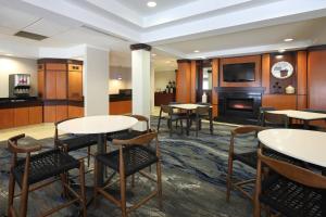 a room with tables and chairs and a fireplace at Fairfield Inn & Suites by Marriott Millville Vineland in Millville