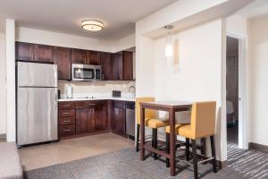 a kitchen with a table and chairs and a refrigerator at Residence Inn by Marriott Austin Airport in Austin