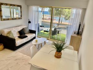 een woonkamer met een bank en een tafel bij Front de mer,plage, piscine, parking in Cagnes-sur-Mer