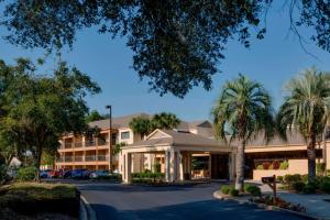 a hotel with palm trees in front of a building at Courtyard by Marriott Ocala in Ocala