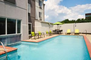 a swimming pool with chairs and a table and an umbrella at SpringHill Suites Nashville MetroCenter in Nashville