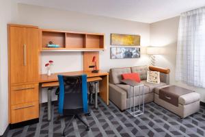a living room with a desk and a chair and a couch at TownePlace Suites Bowie Town Center in Bowie