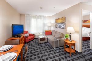 a living room with a couch and a tv in a room at TownePlace Suites Bowie Town Center in Bowie