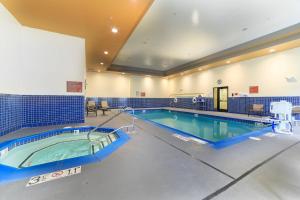 a large swimming pool in a large room with a pool at TownePlace Suites Farmington in Farmington