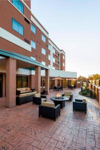 a building with a patio with couches and tables at Courtyard by Marriott Kalamazoo Portage in Portage