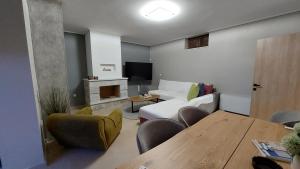 a living room with a white couch and a fireplace at Villa Lina Salamina in Ambelákia