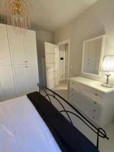 een slaapkamer met een bed en een dressoir met een lamp bij Elena Apartment - View Lake - Private Garage in Bardolino