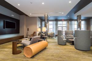 a lobby with a waiting room with chairs and a tv at Courtyard by Marriott Fayetteville Fort Bragg/Spring Lake in Spring Lake