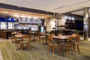 a restaurant with tables and chairs and a bar at Courtyard by Marriott Fayetteville Fort Bragg/Spring Lake in Spring Lake
