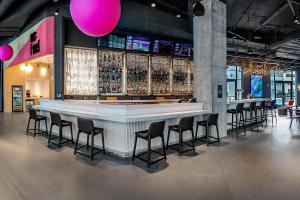 a bar with a bunch of bar stools at Aloft Columbus Easton in Columbus